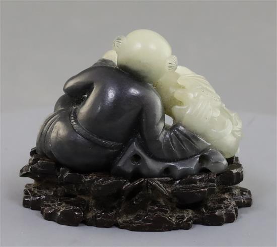 A Chinese pale celadon and grey jade figure of a seated boy, 5.7cm excluding carved wood stand